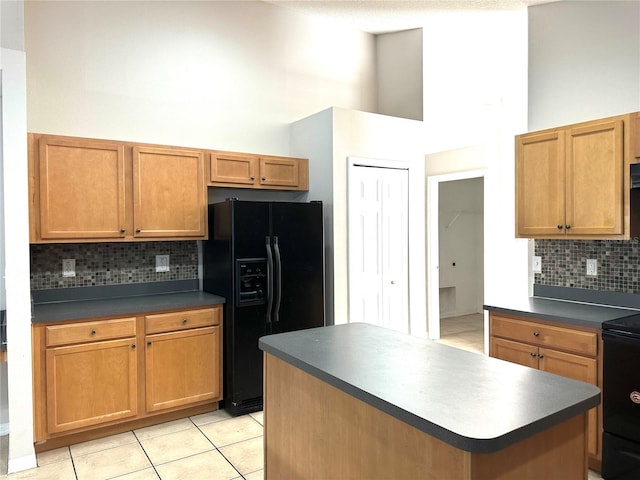 kitchen with black appliances, light tile patterned floors, a center island, and backsplash