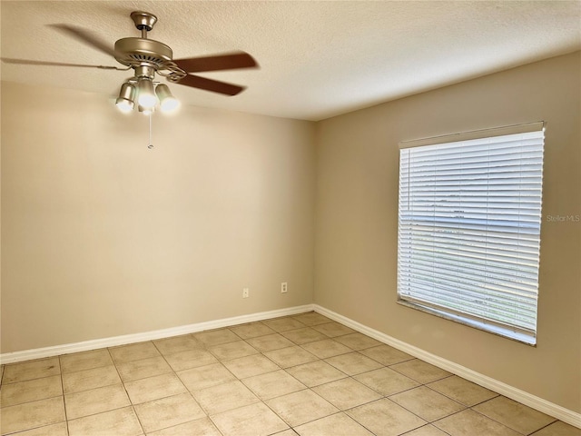 tiled spare room with a textured ceiling and ceiling fan