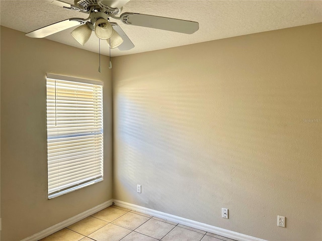 empty room with ceiling fan, a textured ceiling, and light tile patterned flooring