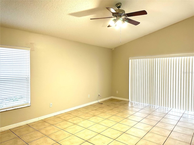 spare room featuring a textured ceiling, ceiling fan, vaulted ceiling, and light tile patterned flooring