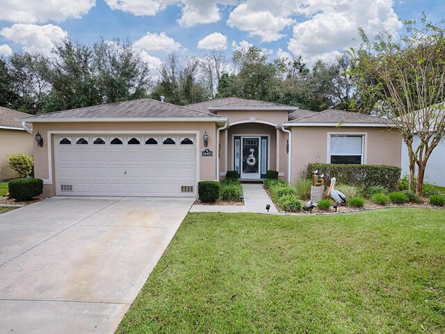 ranch-style home featuring stucco siding, driveway, a front yard, and a garage