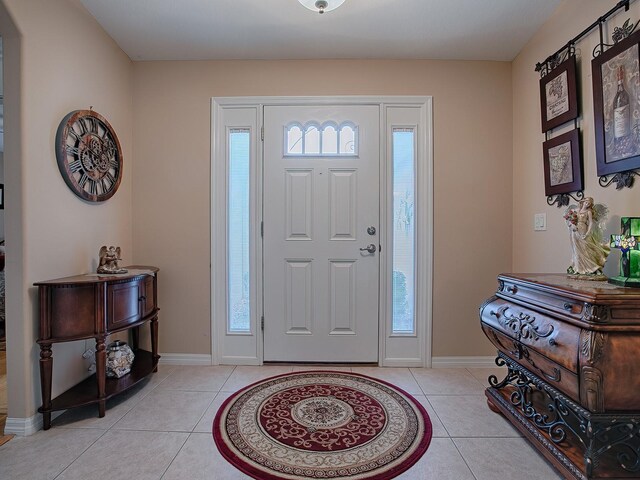entrance foyer with light tile patterned floors and baseboards