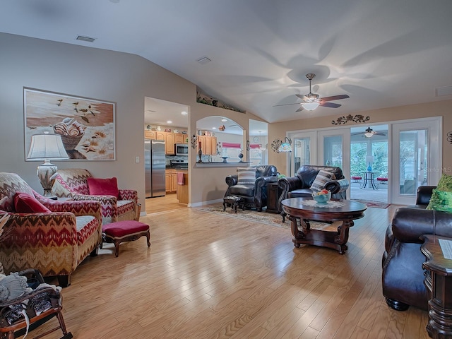 living room featuring vaulted ceiling, ceiling fan, light hardwood / wood-style flooring, and french doors