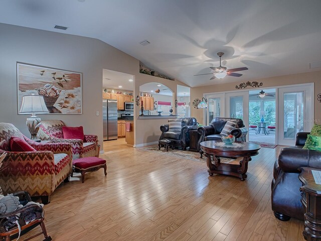 living area with lofted ceiling, light wood-style floors, and ceiling fan