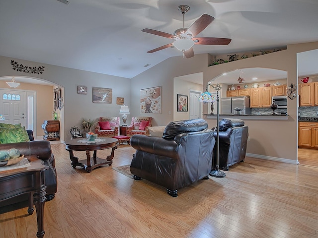 living room featuring ceiling fan, vaulted ceiling, and light hardwood / wood-style floors