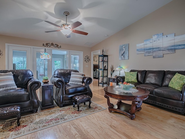 living room with lofted ceiling, ceiling fan, light wood-type flooring, and french doors