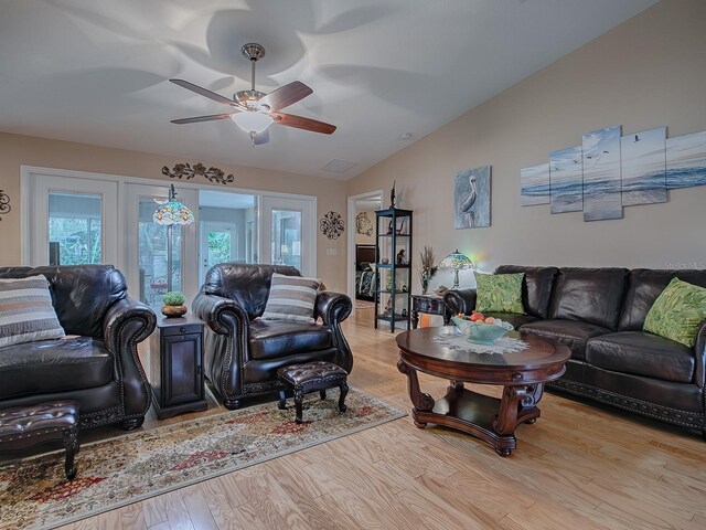 living area featuring lofted ceiling, wood finished floors, and a ceiling fan
