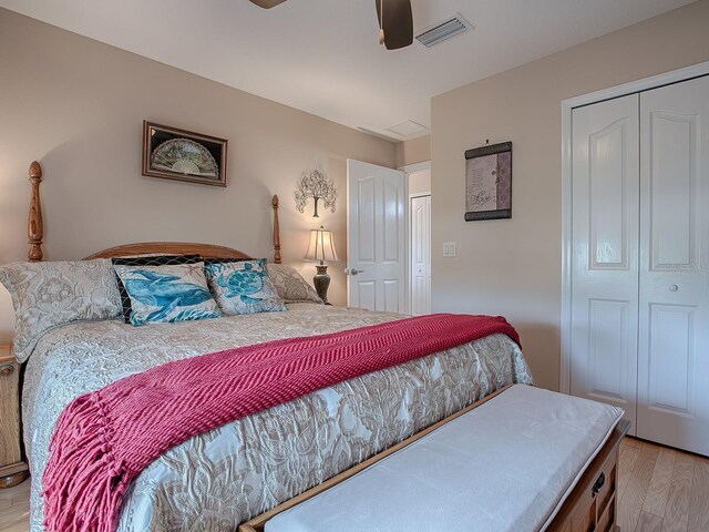 bedroom featuring light wood-style floors, a ceiling fan, and a closet