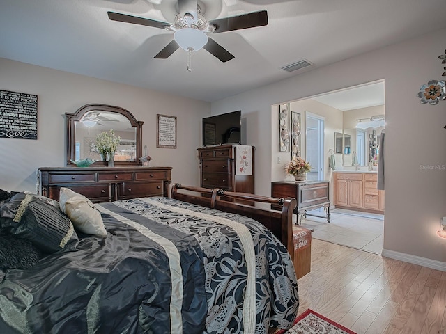 bedroom with ceiling fan, ensuite bath, and light hardwood / wood-style flooring