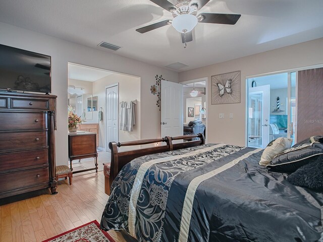 bedroom featuring light wood finished floors, ensuite bath, and ceiling fan