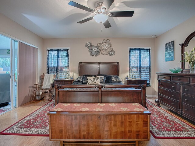 bedroom with multiple windows, wood finished floors, and a ceiling fan