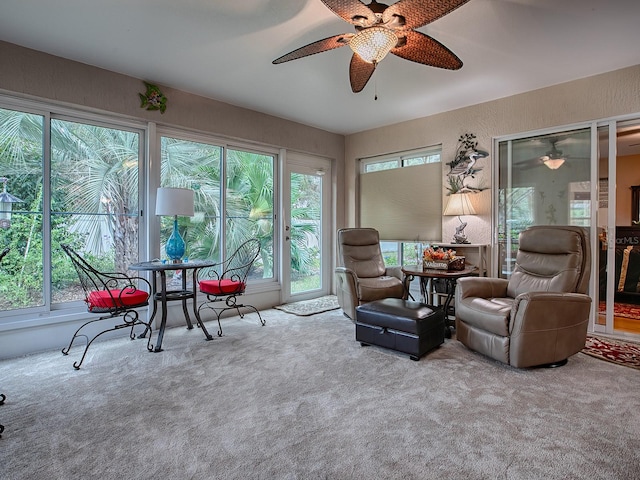 living area featuring carpet and ceiling fan