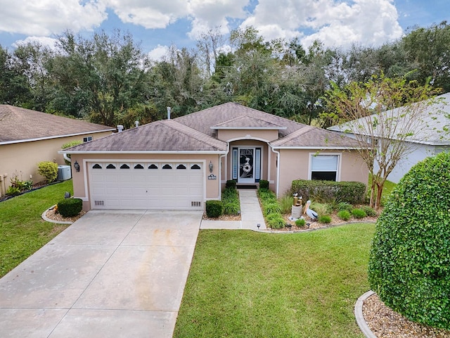 ranch-style home featuring a front lawn, a garage, and central AC unit