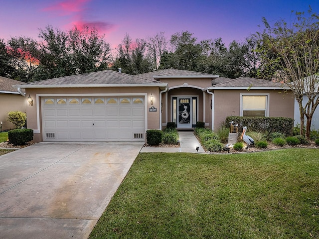 view of front of home featuring a garage and a yard