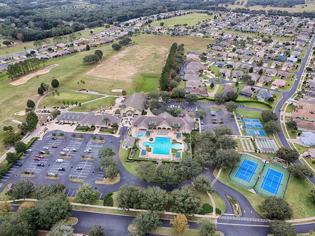 aerial view of property and surrounding area featuring a pool and nearby suburban area
