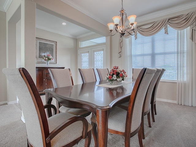 dining room featuring light colored carpet, an inviting chandelier, and ornamental molding