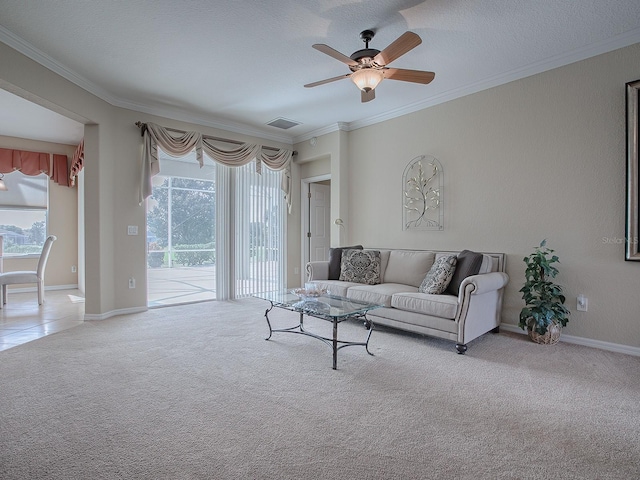 living room featuring ceiling fan, a textured ceiling, crown molding, and carpet floors