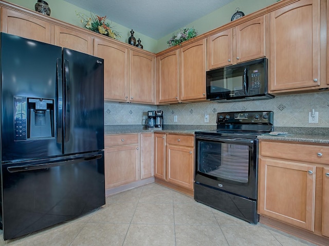 kitchen with a textured ceiling, light tile patterned floors, black appliances, and decorative backsplash