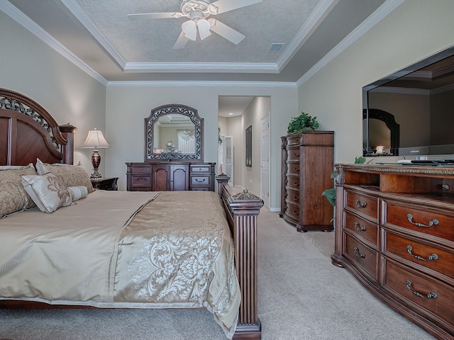 carpeted bedroom featuring ceiling fan, a textured ceiling, a raised ceiling, and ornamental molding