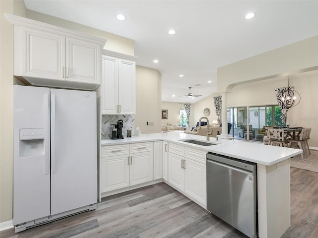 kitchen featuring white refrigerator with ice dispenser, sink, light hardwood / wood-style floors, white cabinets, and dishwasher