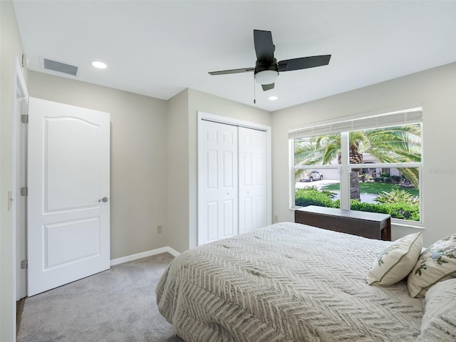 bedroom featuring ceiling fan, light carpet, and a closet