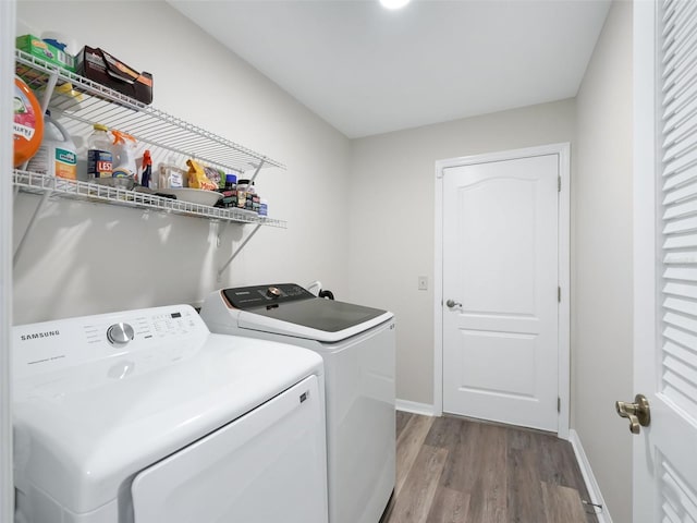 clothes washing area with separate washer and dryer and hardwood / wood-style flooring