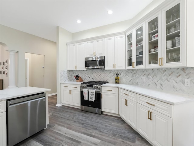 kitchen featuring white cabinetry, stainless steel appliances, tasteful backsplash, and dark hardwood / wood-style flooring