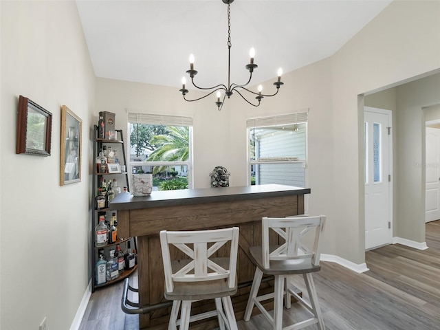 interior space featuring pendant lighting, hardwood / wood-style flooring, and a notable chandelier