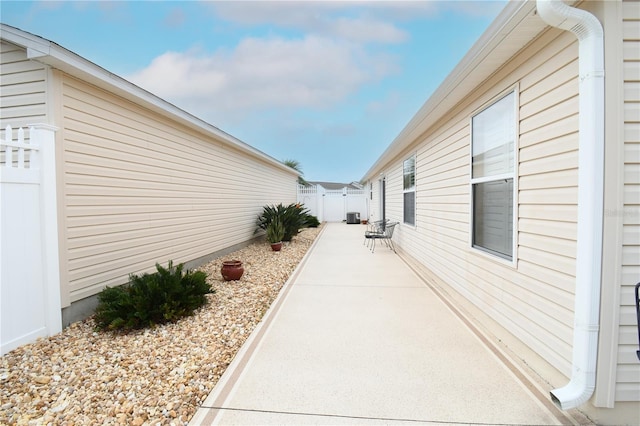 view of property exterior with a patio area and fence