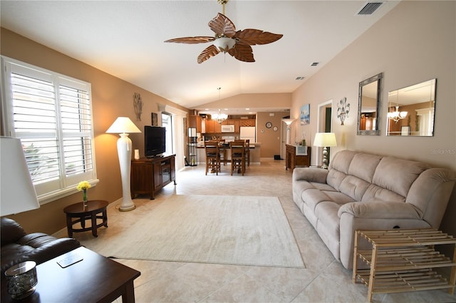 living room featuring light tile patterned floors, ceiling fan with notable chandelier, and lofted ceiling