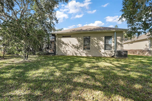 rear view of property with a yard and cooling unit