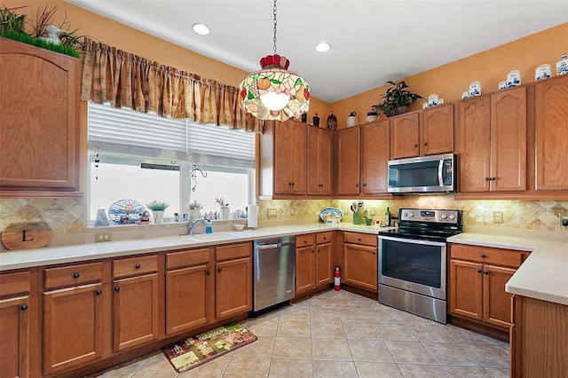 kitchen with pendant lighting, appliances with stainless steel finishes, sink, and tasteful backsplash