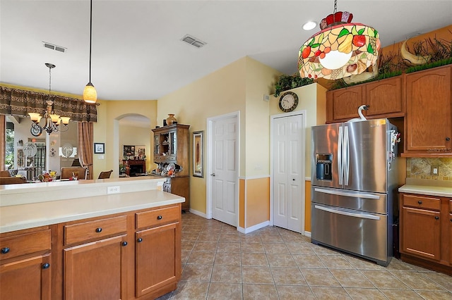 kitchen with tasteful backsplash, light tile patterned floors, decorative light fixtures, a notable chandelier, and stainless steel fridge with ice dispenser