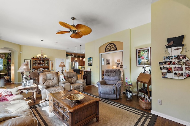 living room with dark hardwood / wood-style floors and ceiling fan with notable chandelier