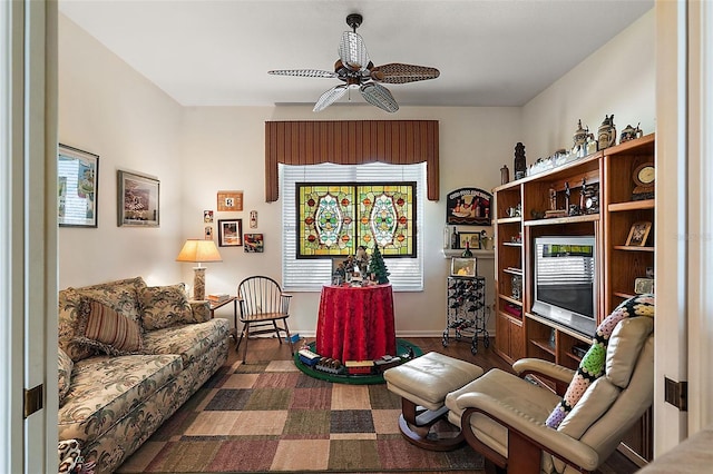 living area with dark wood-type flooring and ceiling fan