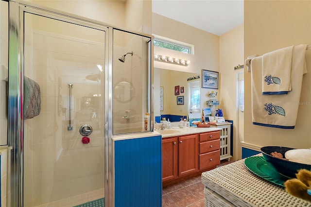 bathroom with an enclosed shower, vanity, and tile patterned flooring