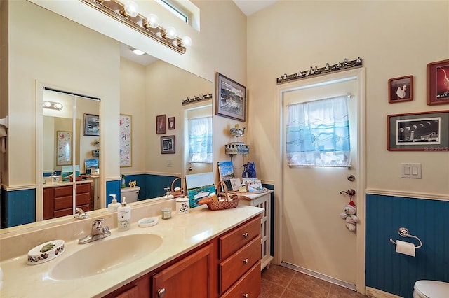 bathroom with vanity, tile patterned floors, a healthy amount of sunlight, and toilet