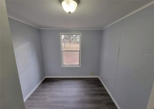 unfurnished room with baseboards, wood finished floors, and ornamental molding