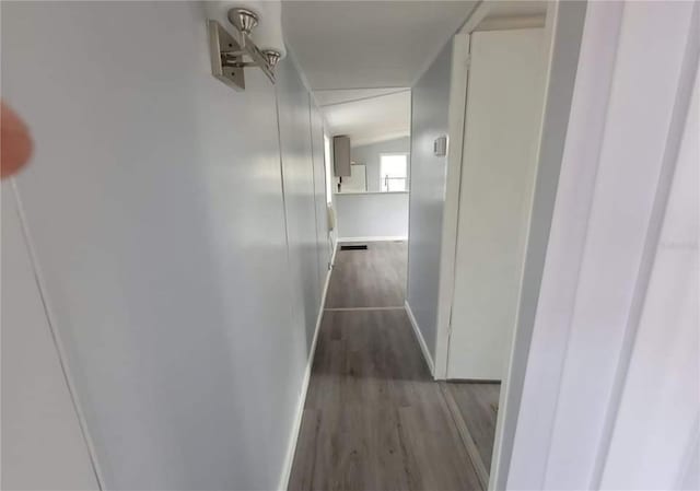 hallway with dark wood-style floors and baseboards