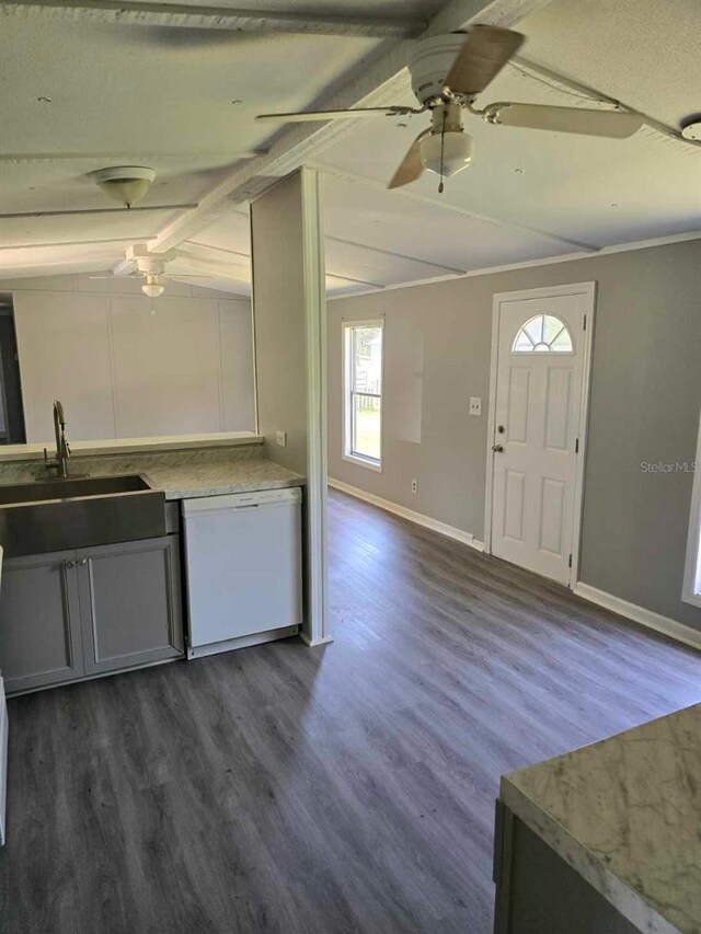 kitchen with lofted ceiling with beams, dark wood-style flooring, white dishwasher, light countertops, and a sink