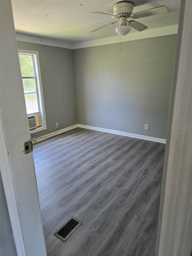 spare room with baseboards, visible vents, and wood finished floors