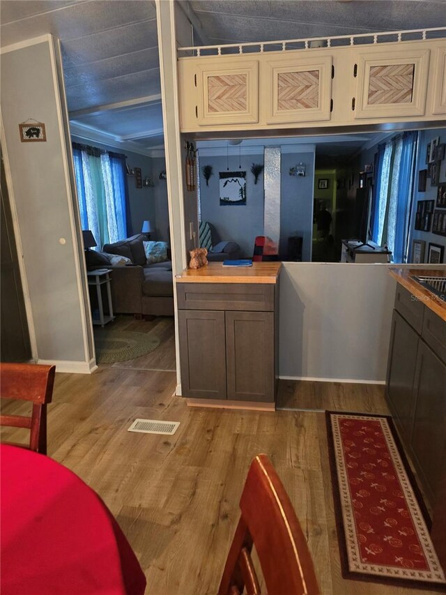 kitchen featuring wooden counters, dark wood-type flooring, and visible vents