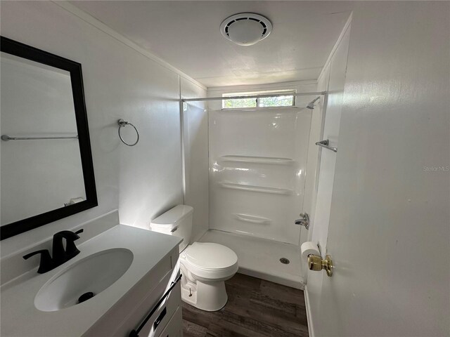 full bathroom featuring vanity, wood finished floors, a shower stall, and toilet