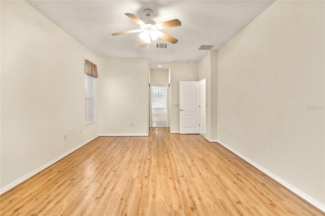 empty room with ceiling fan, a textured ceiling, and light hardwood / wood-style floors