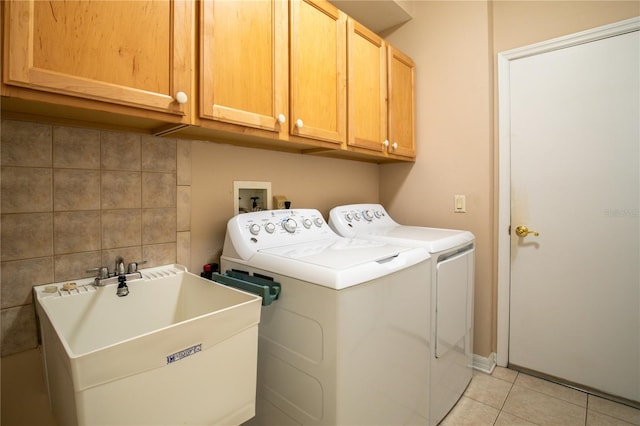 washroom with washing machine and dryer, cabinets, sink, and light tile patterned floors