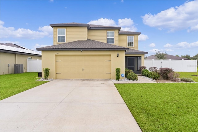 view of front of property with a front yard, a garage, and central AC unit