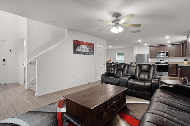 living room featuring ceiling fan and light hardwood / wood-style flooring