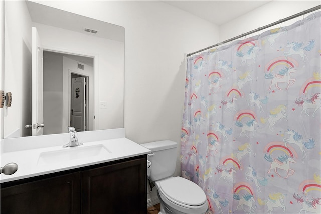 bathroom featuring walk in shower, vanity, and toilet