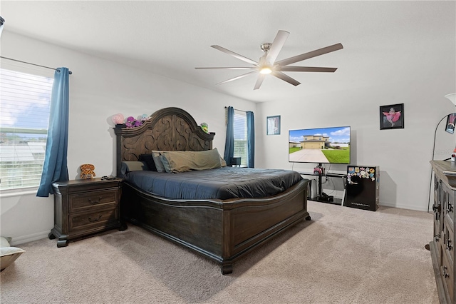 bedroom featuring light carpet, multiple windows, and ceiling fan