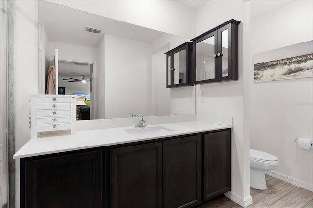 bathroom featuring hardwood / wood-style floors, vanity, ceiling fan, and toilet